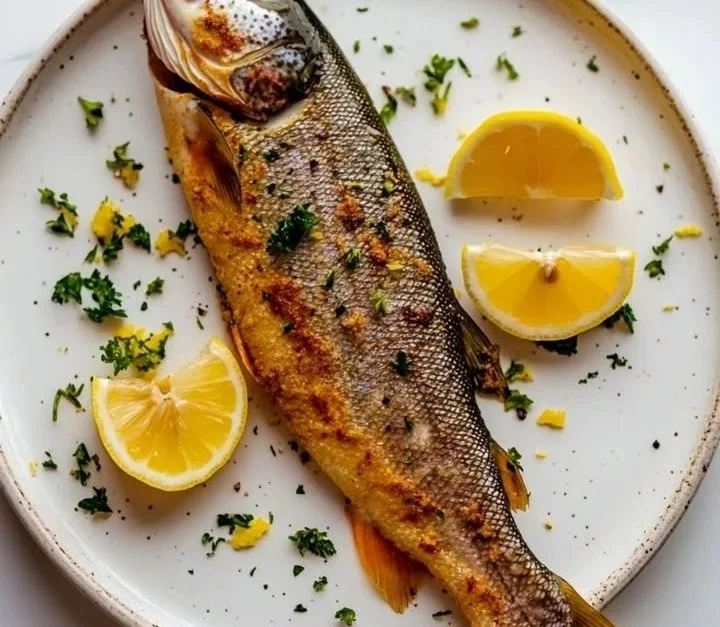 Zubereitung einer Deutschen Forelle Meunière mit frischen Kräutern und Zitrone