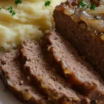 Saftiger deutscher Hackbraten frisch aus dem Ofen mit Kräutern und Beilagen