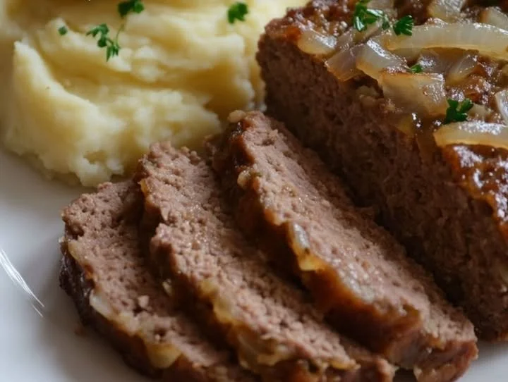 Saftiger deutscher Hackbraten frisch aus dem Ofen mit Kräutern und Beilagen