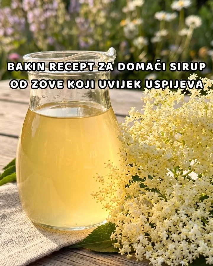 Holunderblüten-Sirup mit Orange und Zitrone in einem Glas auf einem Holzuntergrund