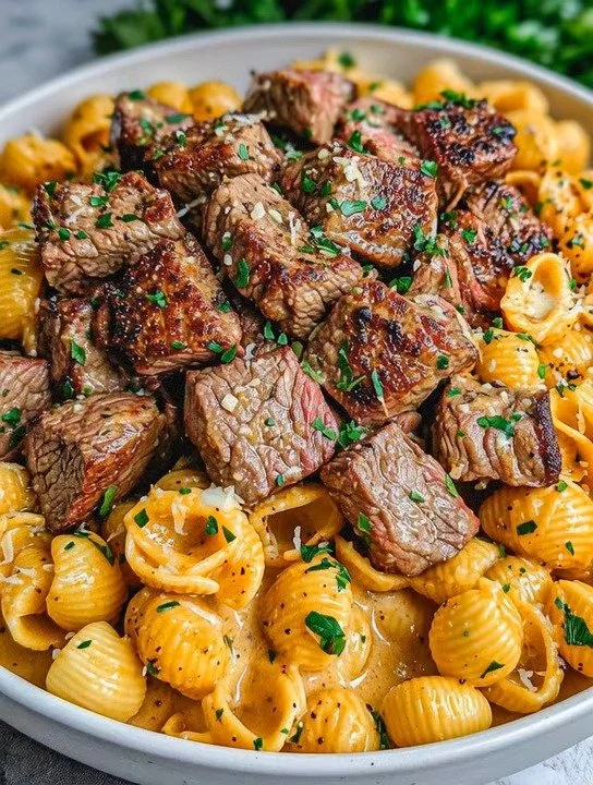 Cajun Steak Bites mit käsiger Knoblauch-Schalen-Pfanne auf einem Teller
