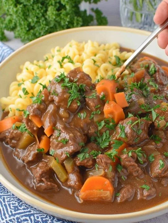 Authentisches deutsches Gulasch mit Fleisch und Gewürzen serviert in einer Schüssel.