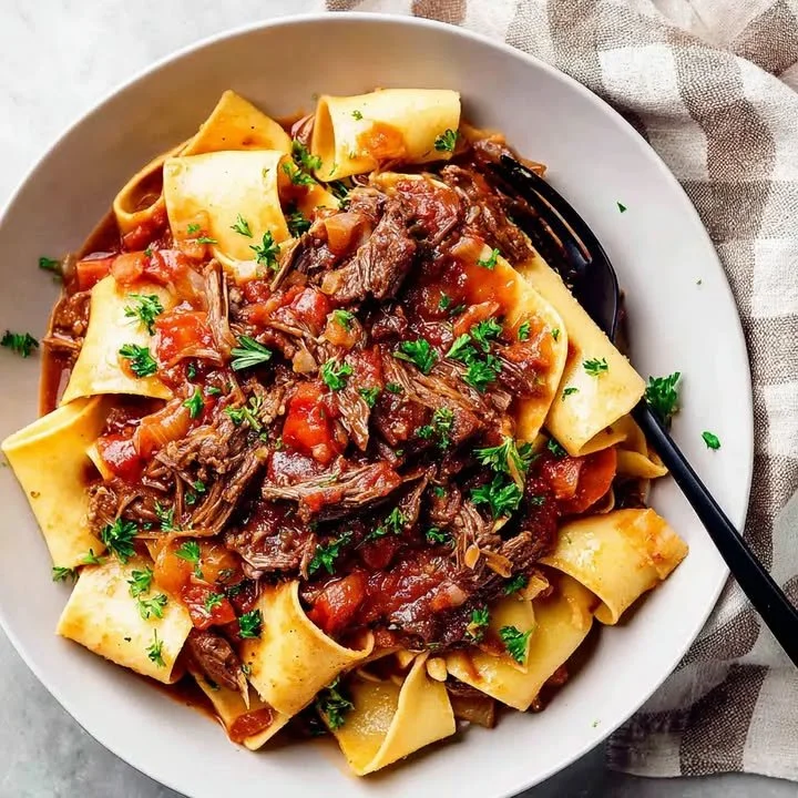 Lammragout mit Pappardelle serviert auf einem Teller